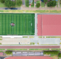 Overhead aerial view of large soccer field and roof of facility