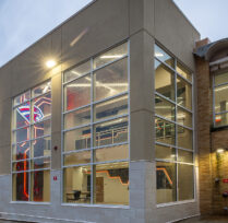Side of building with large windows showing interior