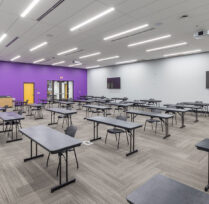 Large classroom and conference space with long desks and chairs