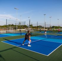 People playing pickleball on the blue courts