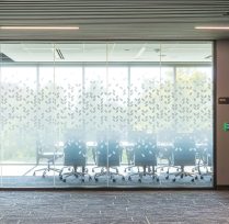 Outside of conference room with decorated wall of glass