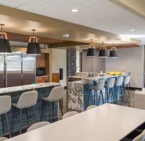 Break area with kitchen, bar tables and chairs