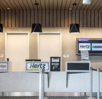 Car rental checkout showing desks and tv screen