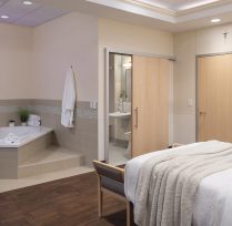 Birthing suite room with bed and hot tub