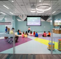 Children sitting on the floor of bright colored room for storytime