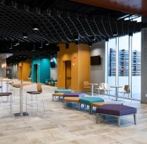 Main lobby with teal and purple chairs and hallway of rooms