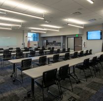 Large meeting room with long desks and many chairs