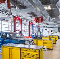 Garage area with 5 car bays and yellow tool shelves