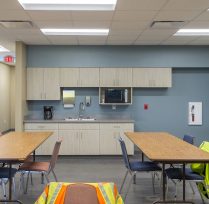 Break area with tables, chairs, and sink