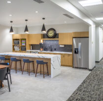 Kitchen lounge area with bar table chairs and refrigerator