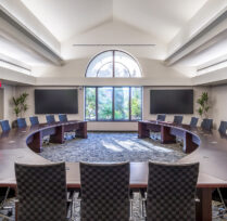 Boardroom with round conference table and chairs in large open room