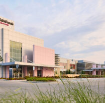 Close up of exterior of center with light pink accents and large windows
